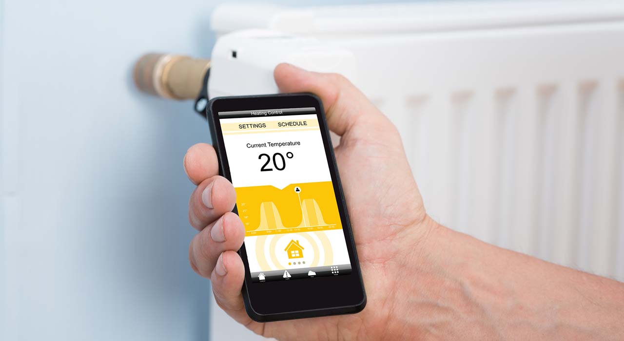 Person Hand Adjusting Temperature Of Thermostat Using Cellphone