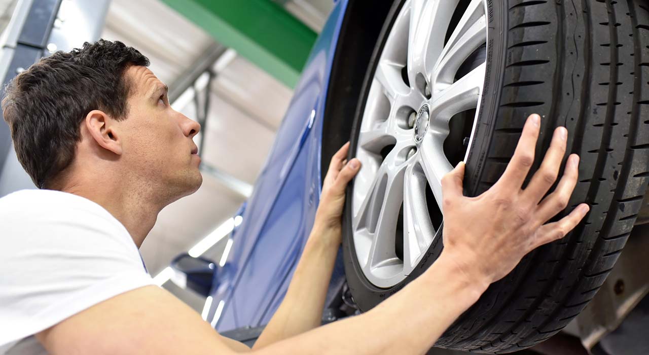 change a tyre // Reifenwechsel in einer Werkstatt durch Monteur